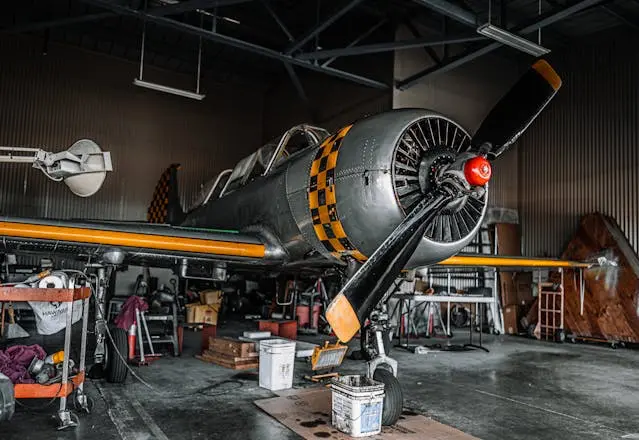 Retro propeller aircraft parked in airdrome shed