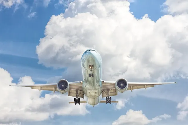 Grau-weißes Flugzeug auf dem Flug in der Nähe von klarem blauem Himmel
